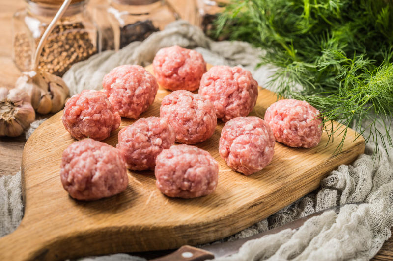 Raw meatballs on the wooden cutting board. Raw meatballs on the wooden cutting board.